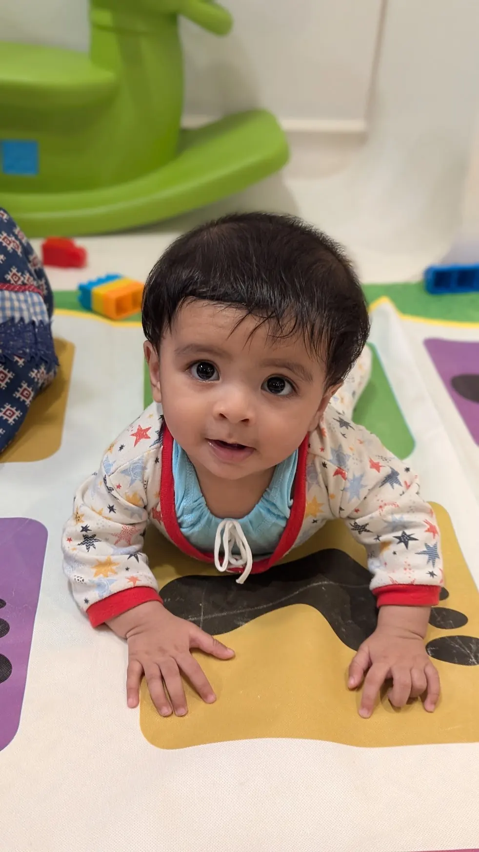 A baby crawling on a play mat